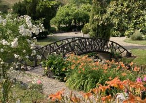 Pont en bois dans un jardin fleuri.